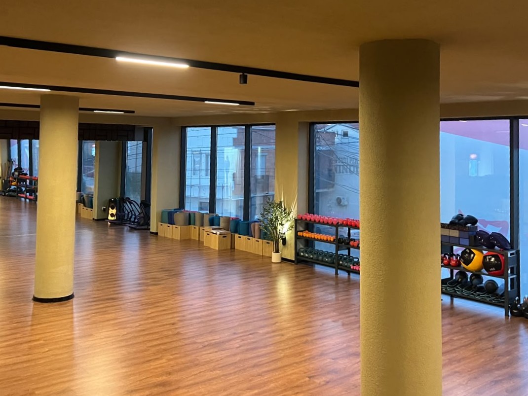 Hapësira e studios me dysheme druri dhe pajisje ushtrimesh